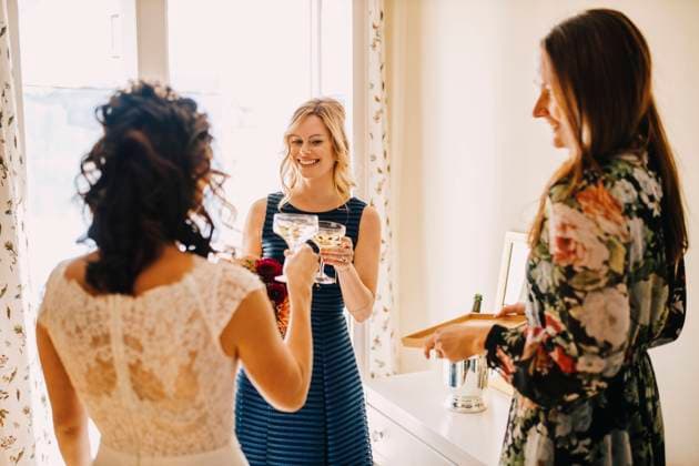 Female friends toasting drinking glass in domestic room model released Symbolfoto property released DAWF01960