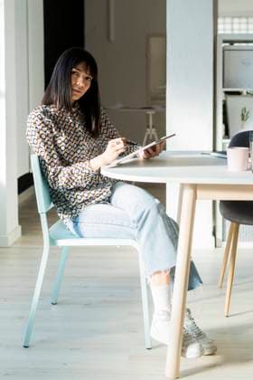 Female professional with graphic tablet sitting on chair at office model released Symbolfoto property released GIOF12362