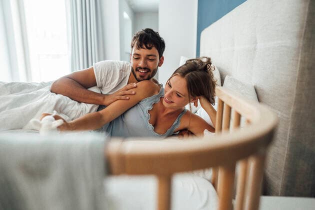 Happy young couple lying on bed together at home model released Symbolfoto property released JOSEF04050