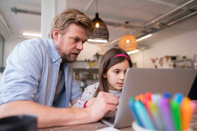 Mature man assisting girl e-learning through laptop at home model released Symbolfoto property released JOSEF04161