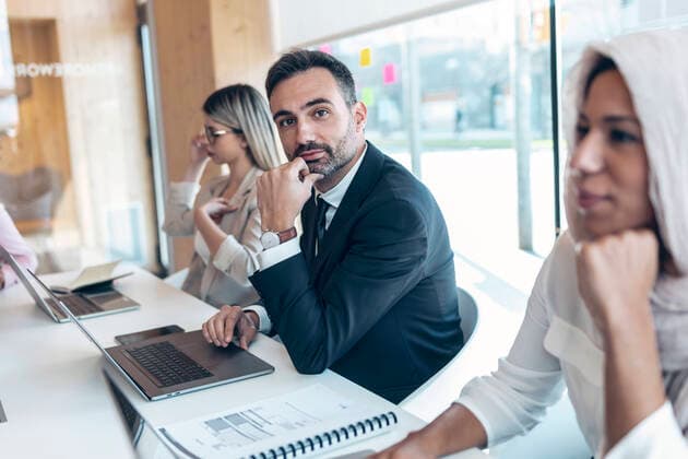 Businessman working with female coworkers in office model released Symbolfoto property released JSRF01514