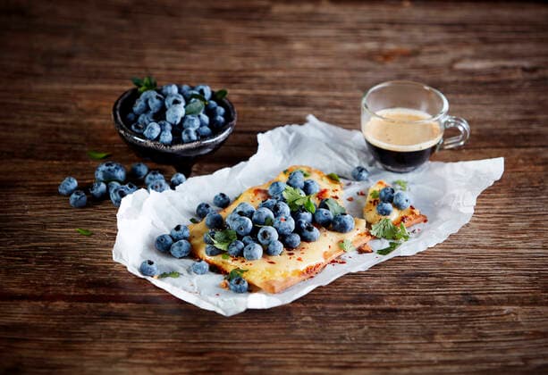 Studio shot of cup of coffee and lemon curd tart with blueberries and cilantro KSWF02222