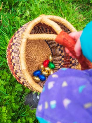 Girl holding basket of Easter egg on grass model released Symbolfoto LAF02710