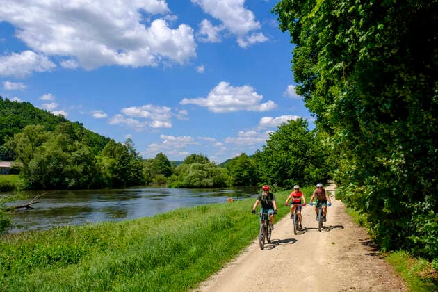 Germany, Bavaria, Duggendorf, Three mature adults cycling along bank of Naab river model released Symbolfoto LBF03515