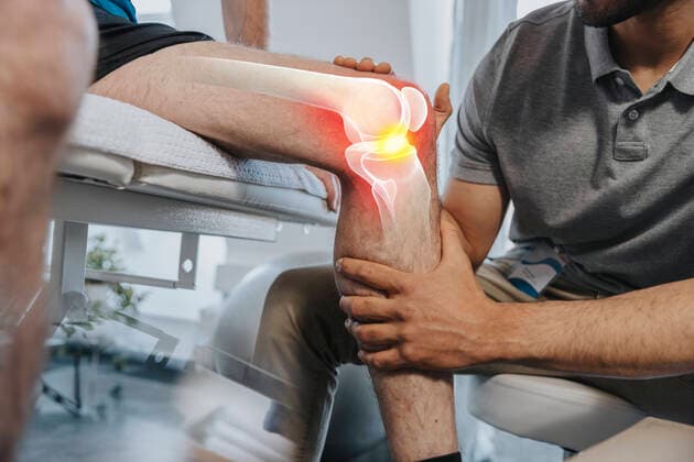 Physical therapist checking knee joint of patient at medical examination room model released Symbolfoto property released LIFIF00025