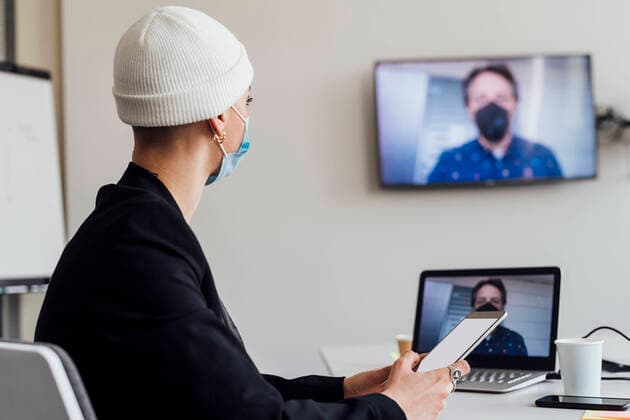 Businesswoman attending meeting through video call with colleague in office during COVID-19 model released Symbolfoto property released MEUF02634