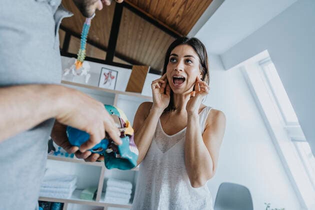 Female patient discussing with male physical therapist about jaw and bruxism in practice model released Symbolfoto property released MFF07698