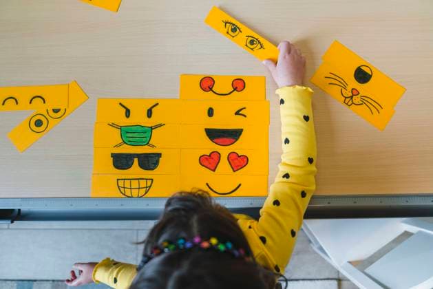 Girl playing with different emoticons on table at home model released Symbolfoto property released MGIF01061