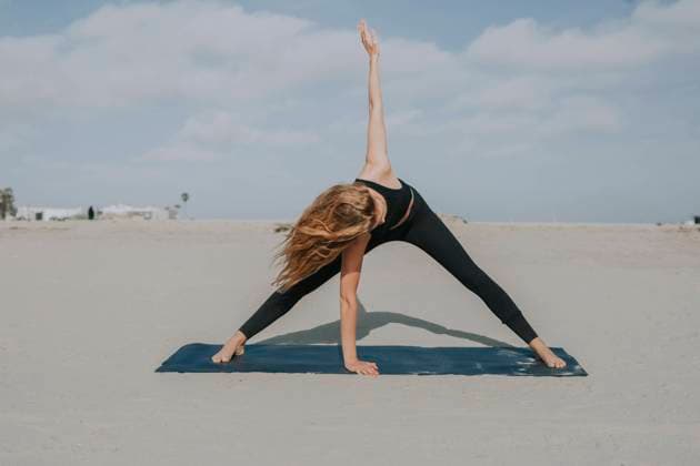IMAGO Creative: Clickbait, Sport und Fitness Female athlete practicing yoga on exercise mat at beach model released Symbolfoto OIPF00650