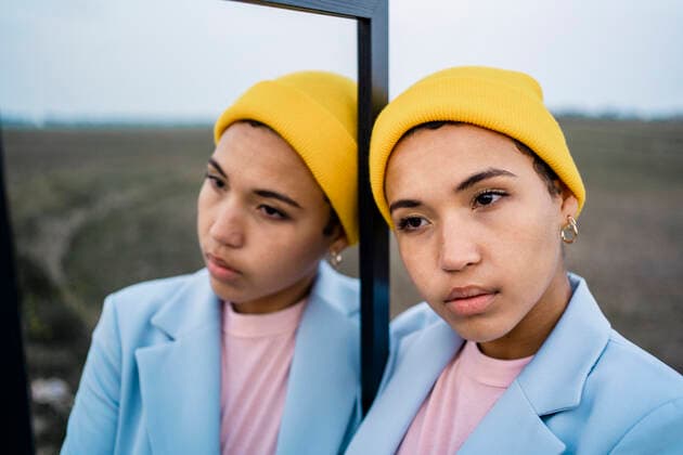 Thoughtful woman in knit hat leaning on mirror model released Symbolfoto RCPF01084