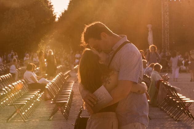 (210619) -- VIENNA, June 19, 2021 -- A couple kiss before the Summer Night Concert starts at the Schoenbrunn Palace in Vienna, Austria, June 18, 2021. The Summer Night Concert 2021 was staged on Friday by the Vienna Philharmonic Orchestra at the Schoenbrunn Palace, a world heritage site in Vienna. About 3,000 spectators are allowed to watch the concert face to face after the COVID-19 restrictions were partially lifted. ) AUSTRIA-VIENNA-SUMMER NIGHT CONCERT GuoxChen 