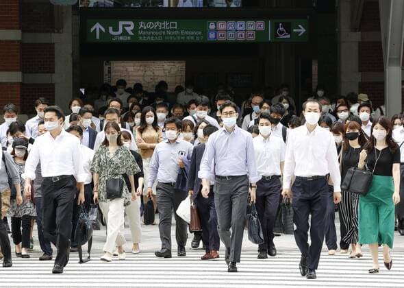 Scene in Tokyo after COVID-19 state of emergency People wearing face masks walk in front of JR Tokyo Station in the Japanese capital on June 21, 2021, during the first morning after Japan ended the COVID-19 state of emergency in Tokyo and eight other prefectures. Tokyo shifted to a quasi-state of emergency until July 11 amid concern about a rebound in infections. 