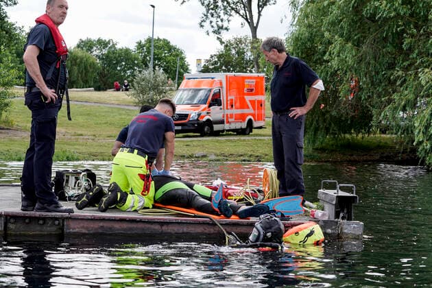Rettungskraefte simmulieren die Rettung eines Ertrinkenden Badeunfall am Fuehlinger See in Koeln Rettungskraefte, Ersthelfer bei der Reanimation, Wiederbelebung eines geretteten Verunglueckten im Badesee bei der Demonstration Rettung eines Ertrinkenden im See gemeinsam mit der Feuerwehr und der DLRG (Deutschen-Lebens-Rettungs-Gesellschaft) am Fuehlinger See in Koeln (Symbolbild) Deutschland *** Rescue workers simulate the rescue of a drowning man in a swimming accident at the Fuehlinger See in Cologne Rescue workers, first aiders during reanimation, resuscitation of a rescued drowning man in the swimming lake during the demonstration rescue of a drowning man in the lake together with the fire brigade and the DLRG German Life Saving Asso
