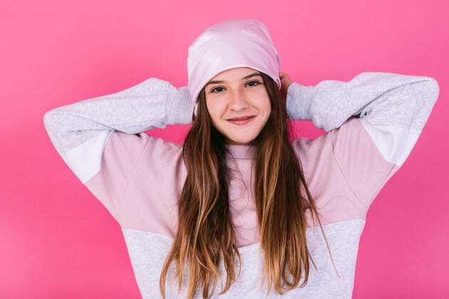 IMAGO Creative: Brustkrebsmonat Content female teenager in casual outfit and headscarf for cancer concept demonstrating strong arms while looking at camera with toothy smile Copyright: xDavidxBenitox Model Released