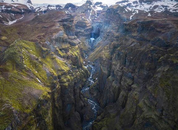 From above stream of clean water falling from rough stony cliffs covered with moss in countryside of Iceland Copyright: xPacoxFarerox Model Released