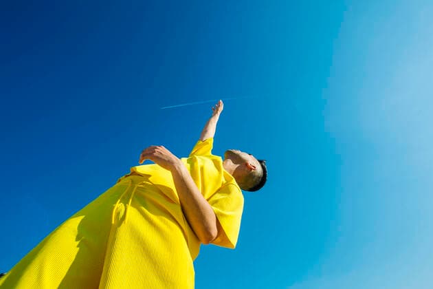 IMAGO Creative: 2021 Favoriten Young man looking up with hands raised in sky during sunny day model released Symbolfoto XLGF02049