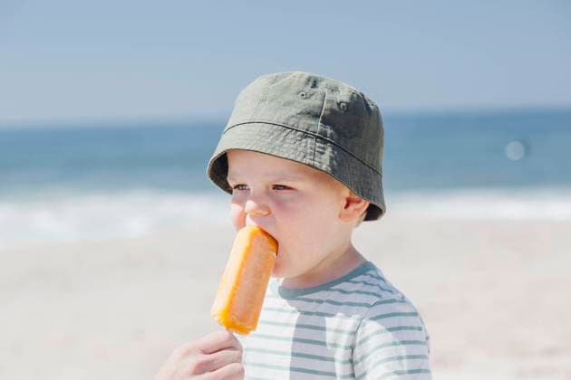 Father feeding ice cream to cute son at beach model released Symbolfoto ACTF00061