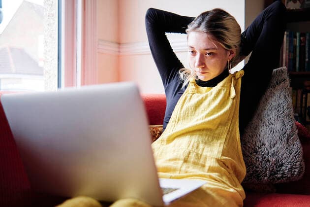 IMAGO Creative: Jahreszeit Winter, Couching Young woman with hands behind head sitting on sofa model released Symbolfoto property released ASGF00436