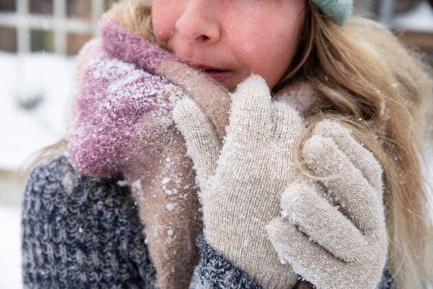 Blond woman wearing scarf and gloves during snow model released Symbolfoto property released FVDF00247