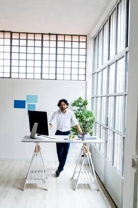 Young businessman standing by desk in office model released Symbolfoto property released GIOF12869