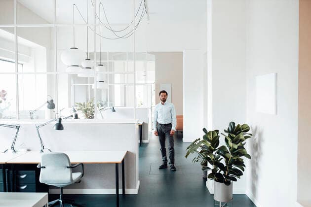 Male entrepreneur staring while standing in office model released Symbolfoto property released GUSF06026