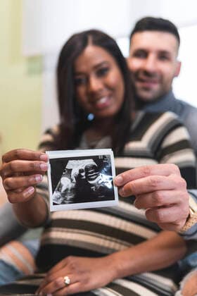 Wife with husband holding ultrasound scan results model released Symbolfoto property released JAQF00656