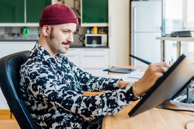 IMAGO Creative: Landleben, Digitalisierung auf dem Land Man wearing knit hat using graphics tablet at home model released Symbolfoto property released MEUF03061