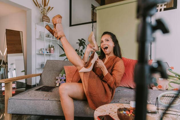 IMAGO Creative: Digitale Welt, Social Commerce Woman showing high heels while vlogging at home model released Symbolfoto property released MFF08087