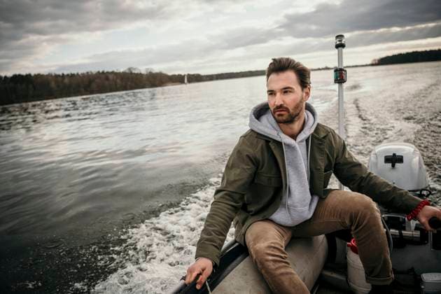 Handsome man sitting in boat at Seddinsee model released Symbolfoto property released MJRF00591