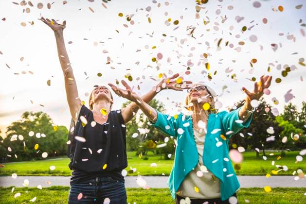 Granddaughter and grandmother playing with confetti at park model released Symbolfoto OIPF00986