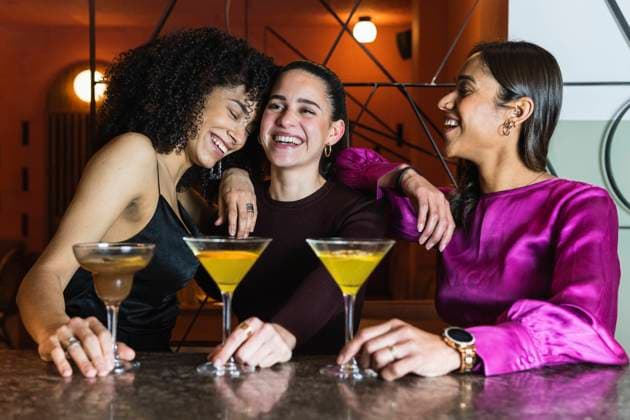 Young friends smiling together by drink at restaurant model released Symbolfoto property released PNAF01733