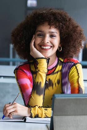 Female university student with hand on chin smiling in library model released Symbolfoto property released PNAF01797
