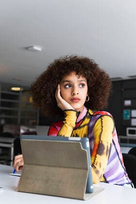 Thoughtful female student with hand on chin looking away in university model released Symbolfoto property released PNAF01814