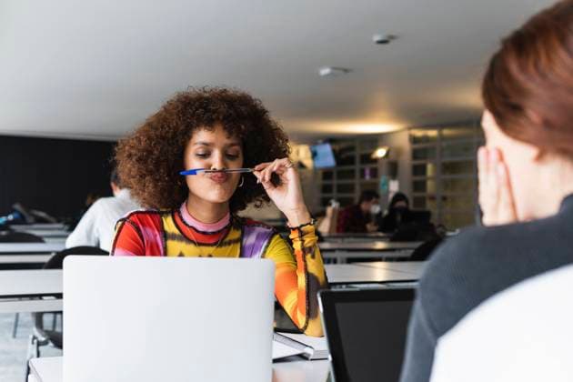 Tschechien, Hochschule streicht wegen KI und Plagiate Bachelorarbeiten Woman holding pen while sitting by friend at university model released Symbolfoto property released PNAF01817