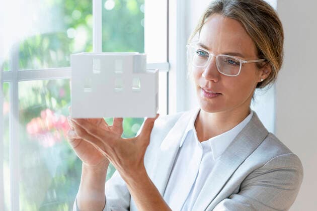 IMAGO Creative: Internationaler Frauenmonat, Geschlechterrollen aufbrechen IMAGO Creative: Klimawandel - Zukunft und Innovation Female professional checking architectural model by window in office model released Symbolfoto property released SBOF03926