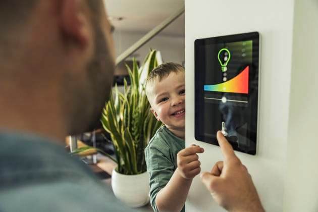 IMAGO Creative: Corporate: Klimaschutz, Digitalisierung und Urbanisierung Smiling boy with father using tablet while adjusting lights at smart home model released Symbolfoto property released UUF23365