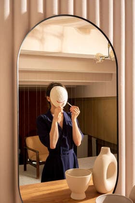 Reflection of woman applying lipstick on white mask model released Symbolfoto property released VPIF04053