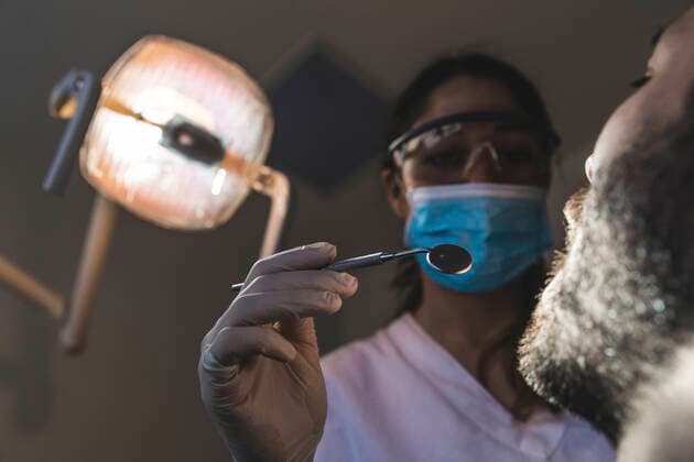 Female dentist holding angled mirror at medical clinic model released Symbolfoto property released WPEF04495