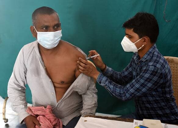 NEW DELHI, INDIA - JUNE 25: A health worker administers a shot of Covid vaccine to a beneficiary Home Less Man, First Vaccination camp for homeless is starting at Yamuna Pushta Night Shelter near Nigam Bodh Ghat opposite Hanuman Mandir on June 25, 2021 in New Delhi, India. (Photo by Sonu Mehta Hindustan Times) Covid Vaccination Camp For Homeless