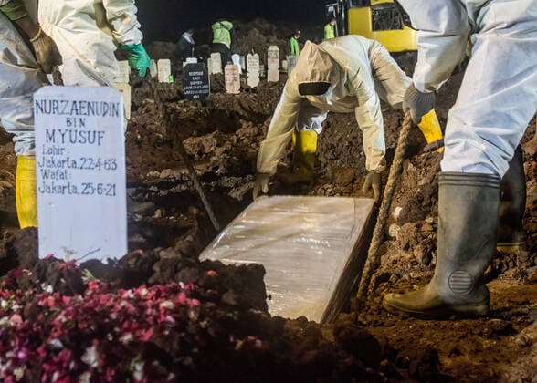 June 25, 2021, Jakarta, Indonesia: (EDITORS NOTE: Image depicts death).Undertakers wearing protective suits as a precaution lower the coffin of a covid-19 victim for burial at Rorotan public cemetery..Indonesia is battling an influx of COVID-19 cases following last month s Idul Fitri holiday where people returned to their hometowns and throngs of people crowded tourist spots. As of Friday (Jun 25), it has reported 2,072,867 COVID-19 cases and 56,371 deaths, placing it among the top five countries with the highest daily number of cases worldwide after Brazil, India, Columbia, and Argentina, data collected by statistics website Worldometer showed. Jakarta Indonesia - ZUMAs197 20210625_zaa_s197_134 Copyright: xAgungxFatmaxPutrax
