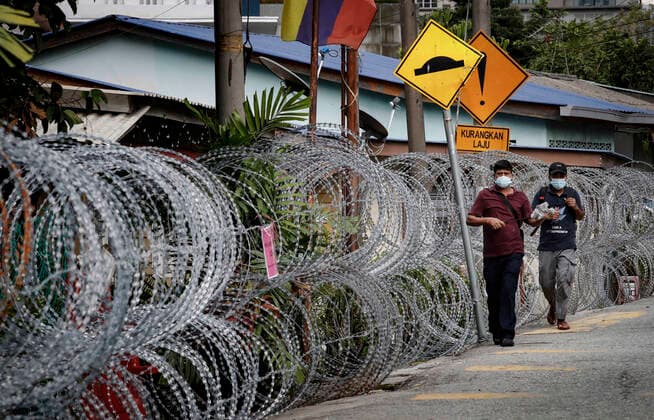 June 27, 2021, Kuala Lumpur, Malaysia: Pedestrians are seen walking past the barbwire at the Segambut Dalam housing area which was placed under the enhanced movement control order (EMCO) due to surge in the number of COVID-19 daily cases recorded..Malaysia government announced the one month full lockdown which is due on Monday will be extended due to the daily high number of coronavirus infections cases reported. Kuala Lumpur Malaysia - ZUMAs197 20210627_zaa_s197_085 Copyright: xWongxFokxLoyx