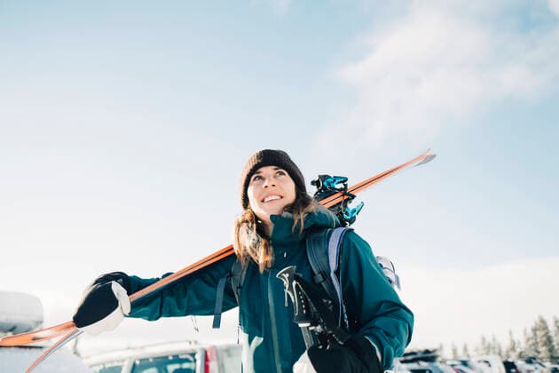 IMAGO Creative: Wintersport, Mode Smiling woman carrying skis during winter against sky Sweden, ?re, model released Copyright: xMaskotx , MA87031