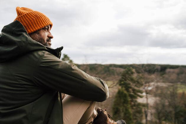 Mature man looking away sitting on mountain against sky Sweden, Stockholm Archipelago, model released Copyright: xMaskotx , MA87313