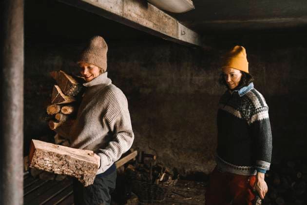 Mature woman looking at girlfriend collecting firewood while standing in shed Sweden, Vastergotland, model released, property released Copyright: xMaskotx , MA87461