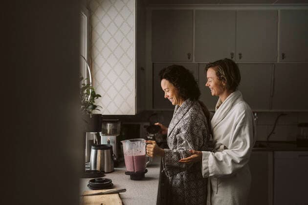 IMAGO Creative: Clickbait, Rezepte und Kochen Smiling woman looking at girlfriend making smoothie in kitchen Sweden, Vastergotland, model released, property released Copyright: xMaskotx , MA87497