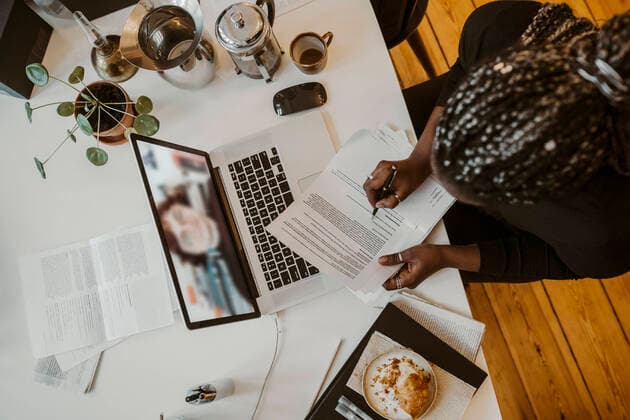 Female professional writing while attending video call with colleague through laptop in home office Germany, Berlin, model released, property released Copyright: xMaskotx , MA87576