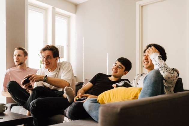 IMAGO Creative: Herbst, in Gesellschaft spielen Young male friends playing video game in living room Sweden, Gothenburg, model released, property released Copyright: xMaskotx , MA87664