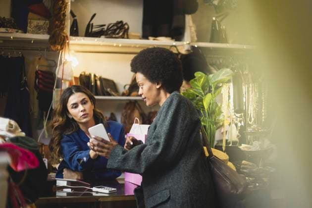 IMAGO Creative, Internationaler Frauenmonat, Entrepreneurinnen Female owner and customer using smart phone at store Sweden, Stockholm, model released, property released Copyright: xMaskotx , MA87674