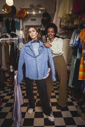 Portrait of female customer trying on shirt while standing by owner in clothing store Sweden, Stockholm, model released, property released Copyright: xMaskotx , MA87682