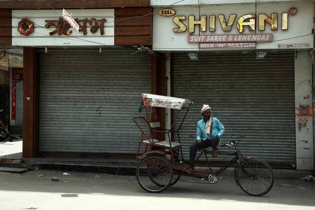 India: Market closed, covid-19 protocol violations Shopkeeper and DCD Staff sitting the outside of closed shops of after the Laxmi Nagar market closed over Covid-19 protocol violations Delhi India Copyright: JyotixKapoor